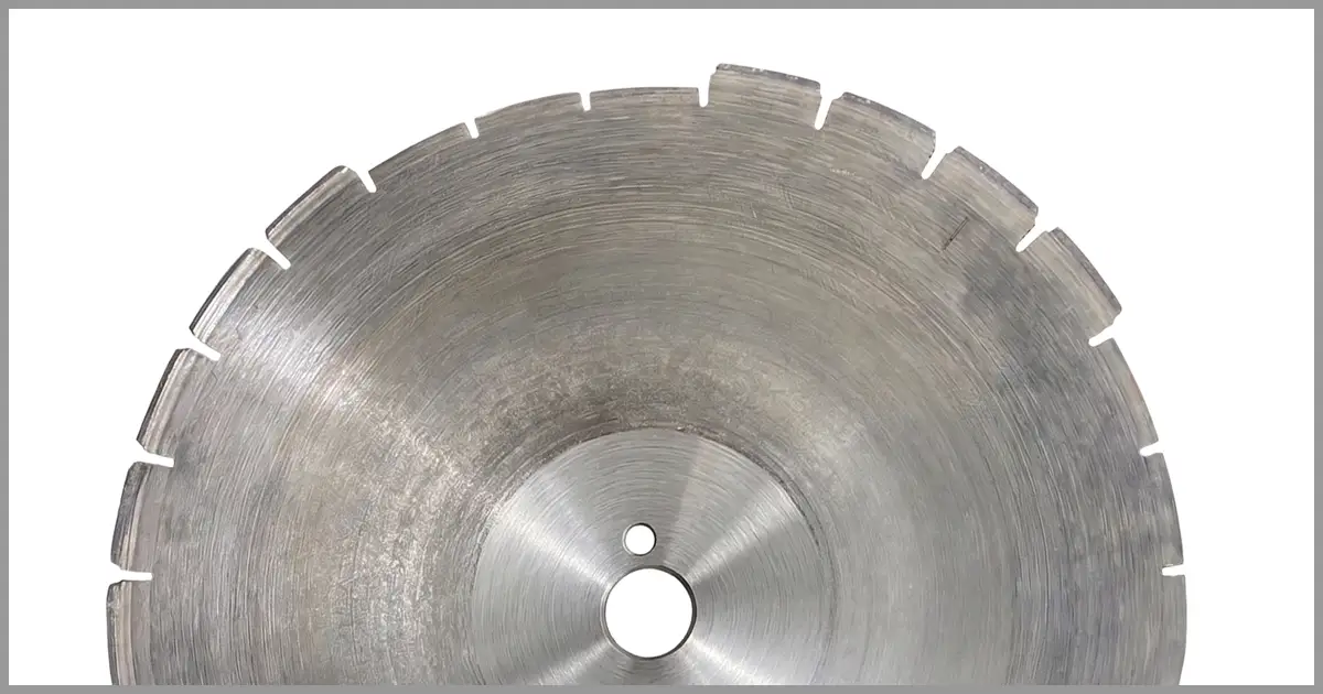 A damaged diamond saw blade with missing cutting segments on the edge.